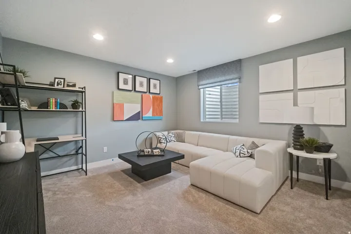 Carpeted living area featuring recessed lighting, a built-in window with privacy blinds, and light gray wall paint