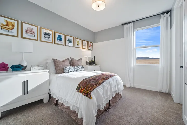 Bedroom featuring a large window, neutral carpeting, and a two-tone painted wall