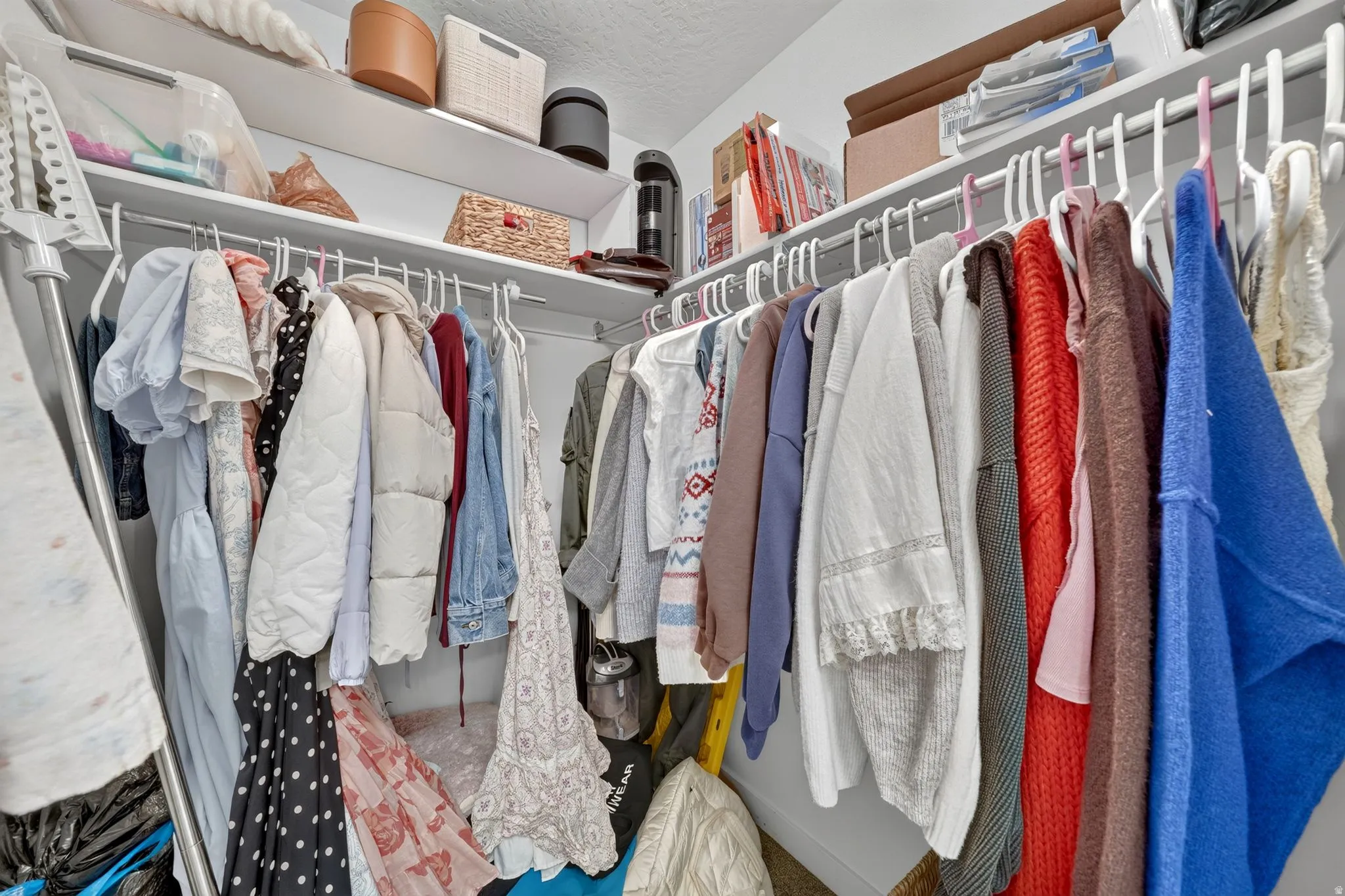 Walk-in closet with white shelving and chrome hanging rods