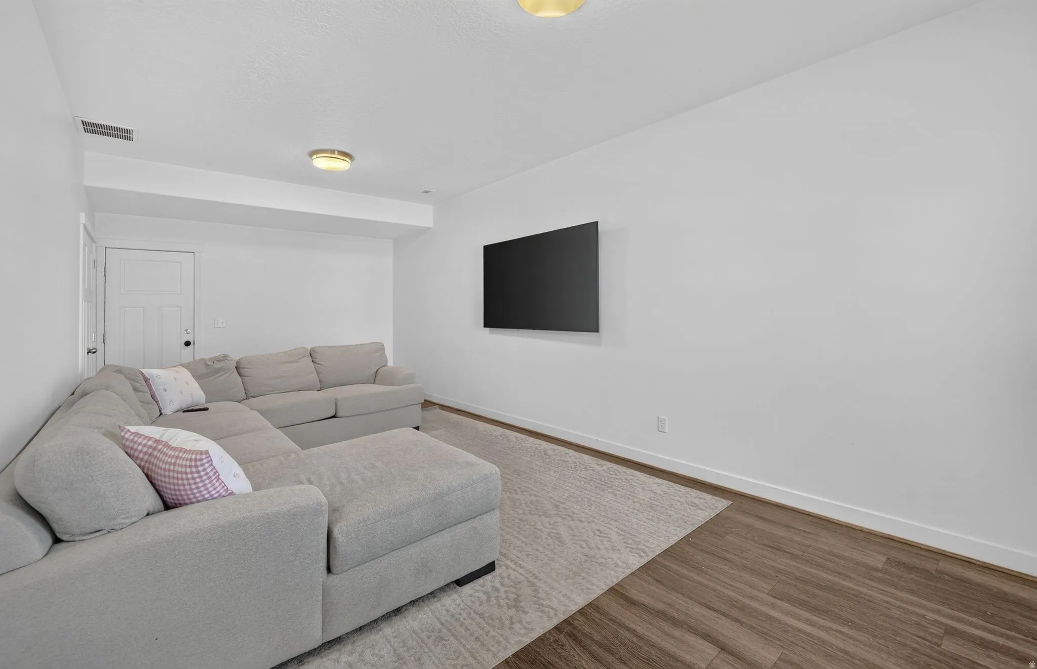 Recreation space featuring wood-finish flooring, white walls, and flush-mount ceiling lighting