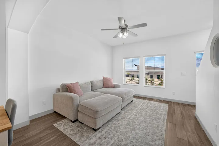 Bright interior space featuring wood-finish flooring, white walls, and a ceiling fan