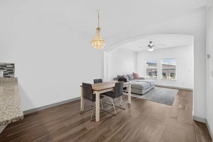 Open-concept living space featuring wood-finish flooring and an arched entryway
