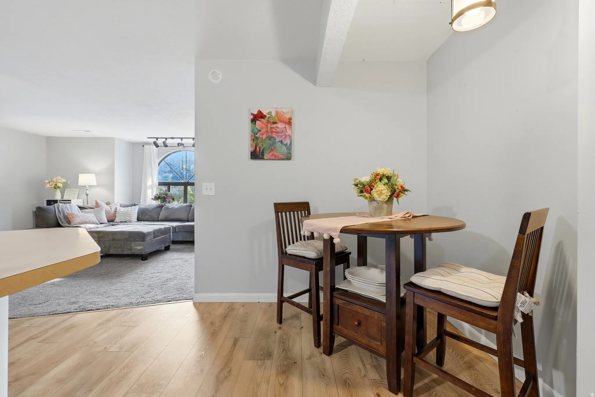 Dining nook featuring wood-finish flooring, a contemporary ceiling light fixture, and light gray wall paint
