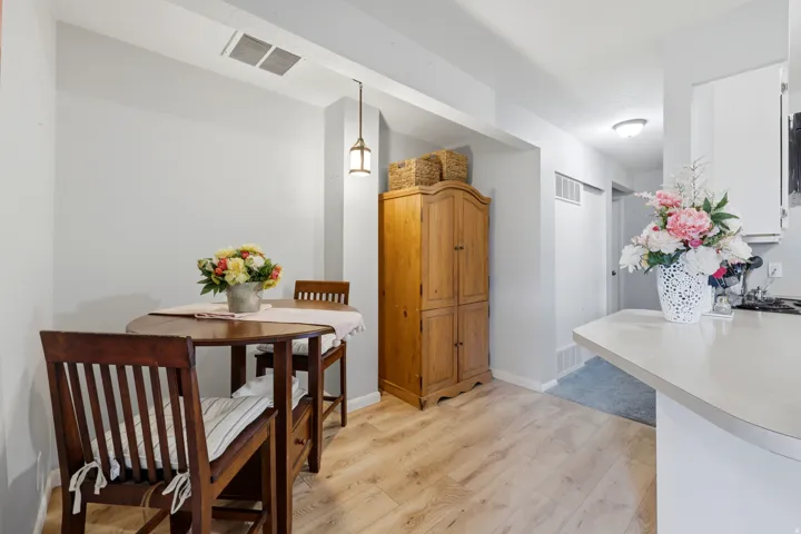 Dining area featuring wood-finish flooring and a built-in pendant light fixture
