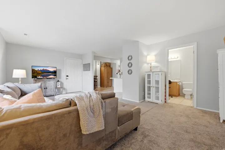 Carpeted living area featuring light gray walls and white trim