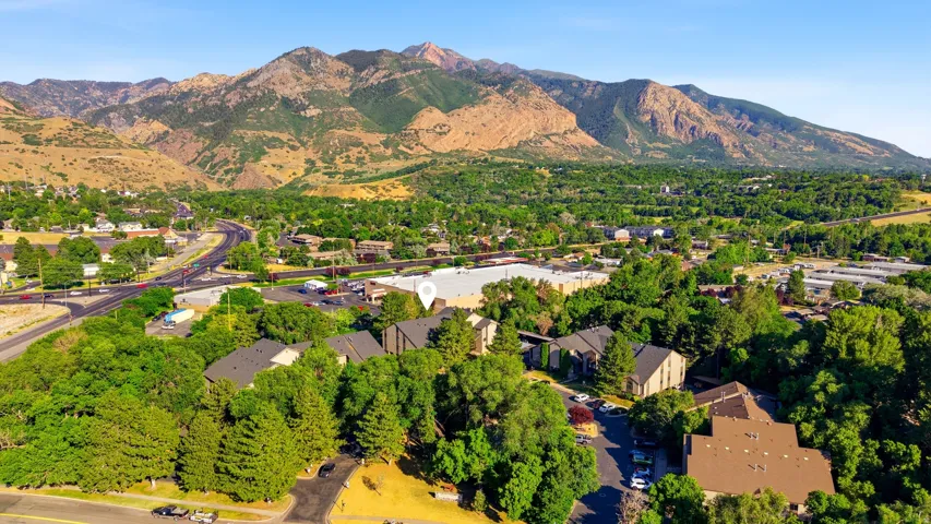 Aerial perspective showcasing a residential area nestled at the base of extensive mountain ranges