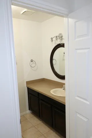 Bathroom featuring a dark wood-finish vanity with a beige countertop and an undermount sink