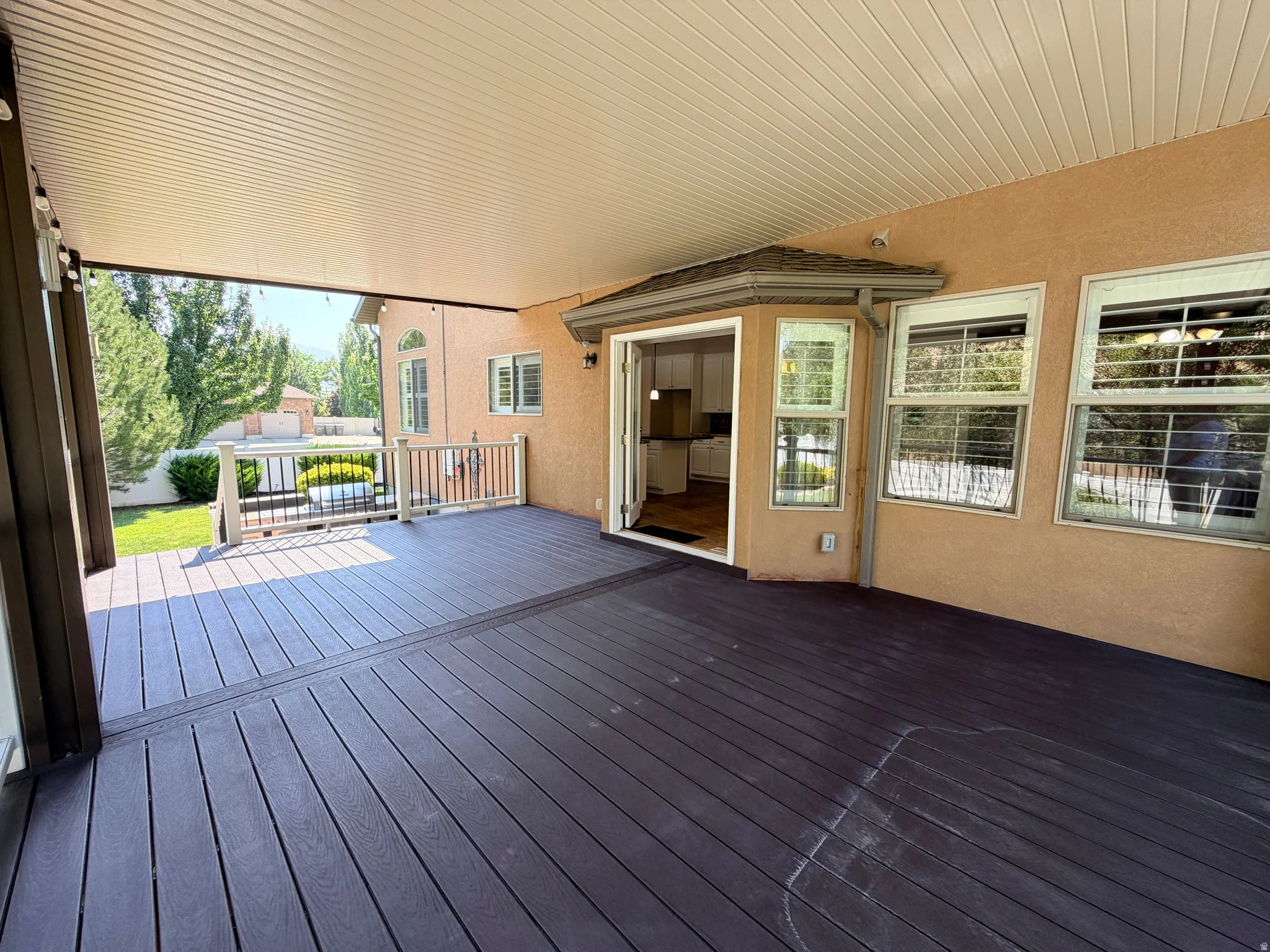 Expansive covered deck featuring composite decking in contrasting finishes, offering generous entertaining space