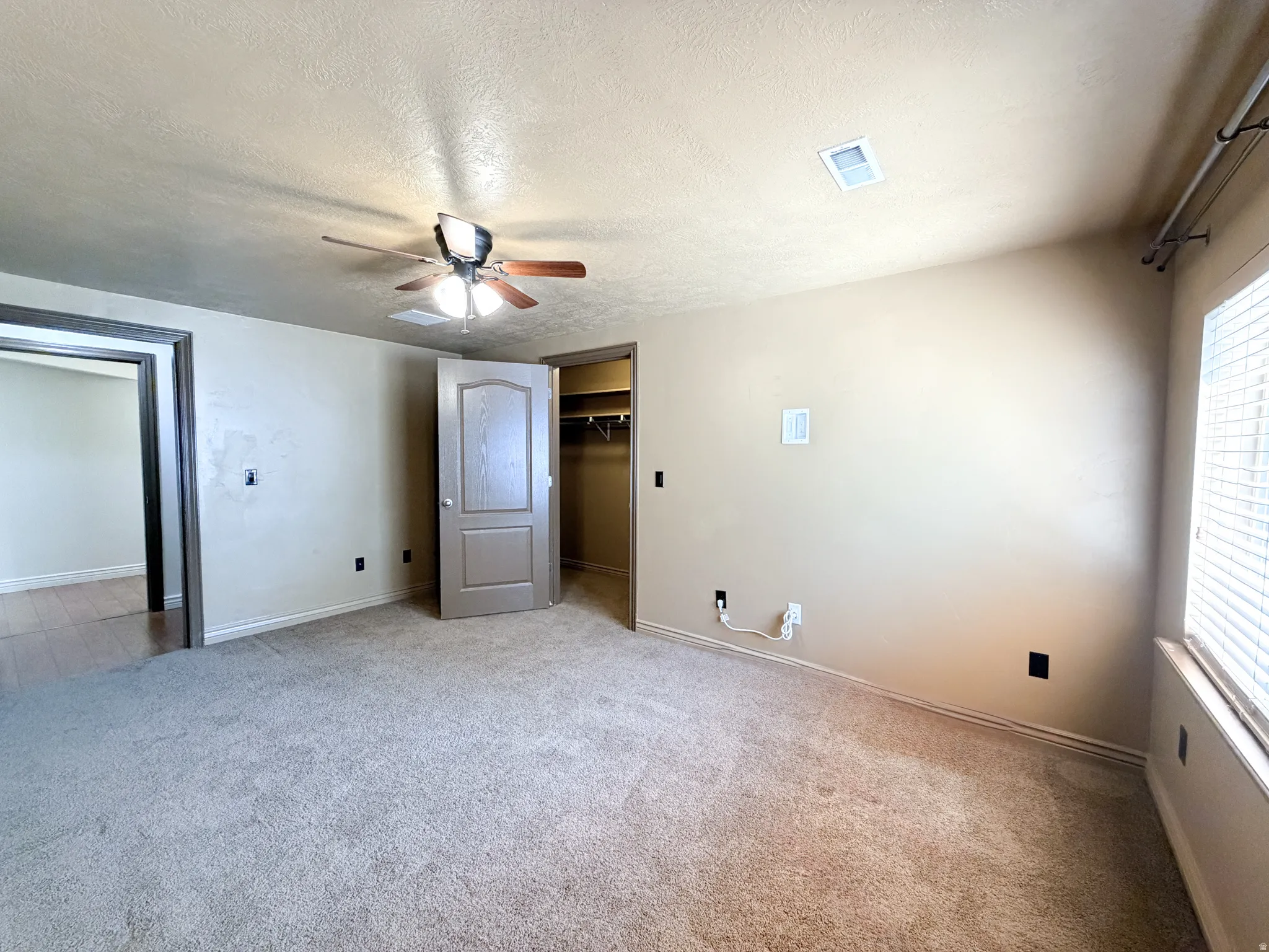 Bedroom 4 Carpeted flooring, ceiling fan, window with blinds, and a built-in closet with shelving