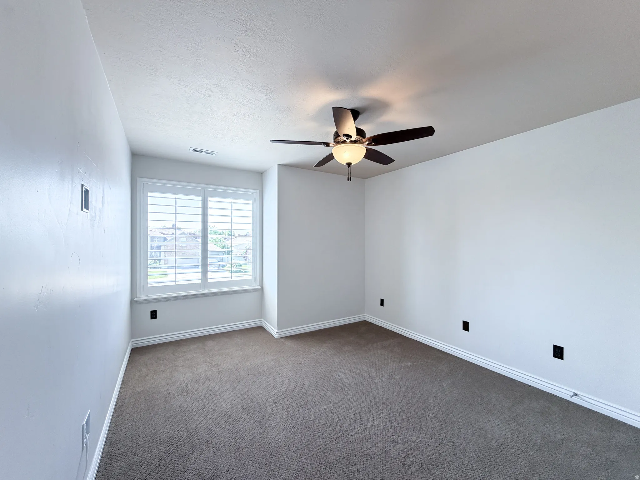 Bedroom 3 Plush carpet flooring, a ceiling fan with integrated lighting, window with white plantation shutters, and light-toned wall finishes