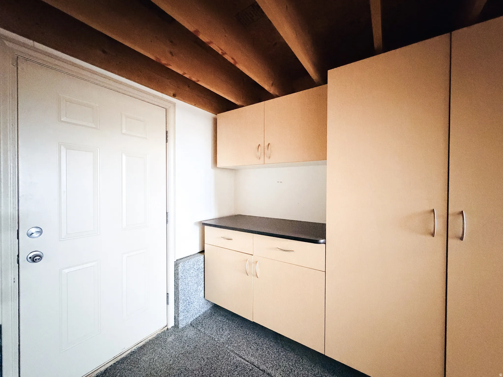 Built-in cabinetry with a dark countertop and upper storage