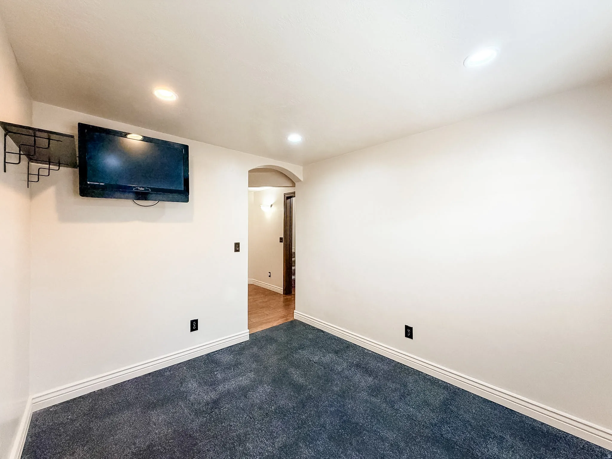 Recessed ceiling lighting, wall-mounted television bracket, and archway
