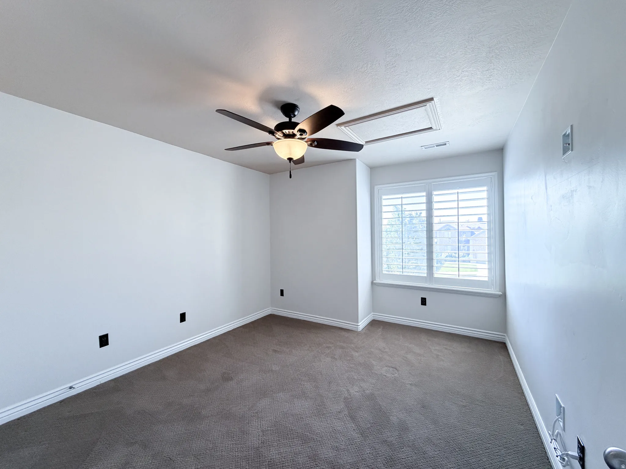 Bedroom 2 Neutral wall paint, carpet flooring, a ceiling fan with integrated lighting, and window with plantation shutters