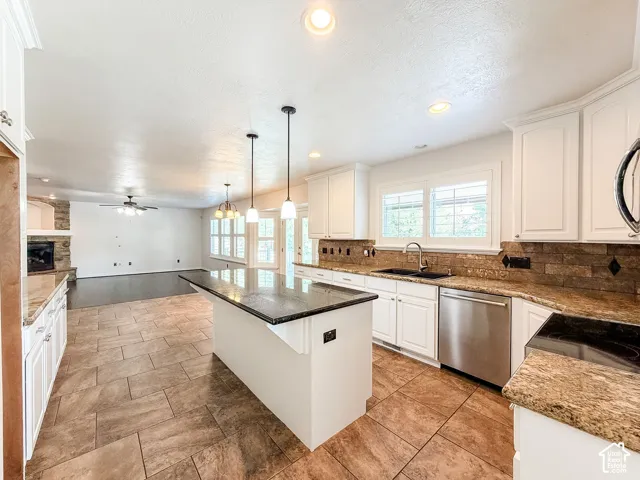 Kitchen featuring a large island, white cabinetry, integrated stainless steel appliances, and tile flooring