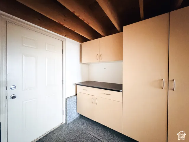 Built-in cabinetry with a dark countertop and upper storage