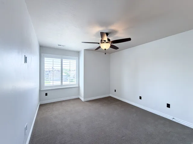Bedroom 3 Plush carpet flooring, a ceiling fan with integrated lighting, window with white plantation shutters, and light-toned wall finishes