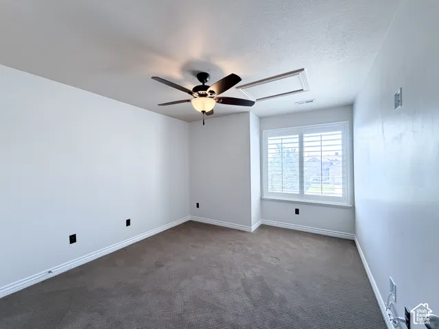 Bedroom 2 Neutral wall paint, carpet flooring, a ceiling fan with integrated lighting, and window with plantation shutters
