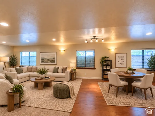 Recessed lighting, warm wall sconces, and multiple windows illuminate the space