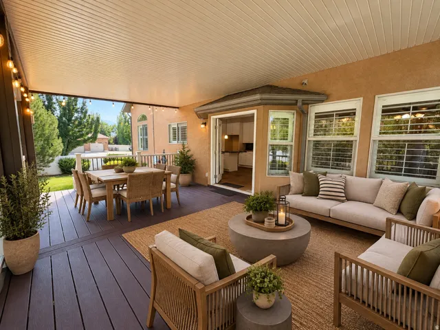 Covered patio featuring a slatted ceiling, dark wood-finish decking, and a bay window