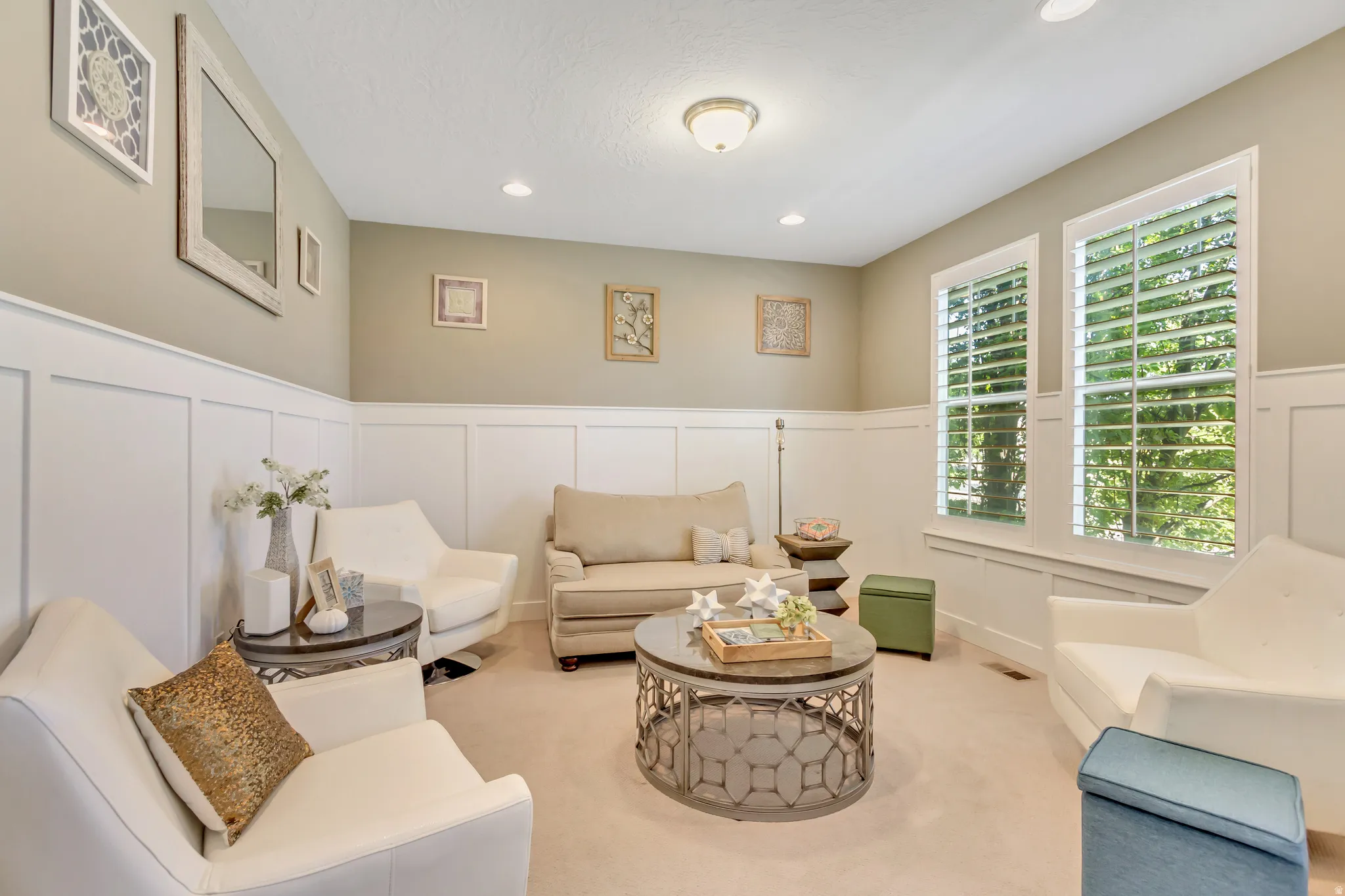 Inviting living area featuring board and batten wall paneling, neutral wall tones, and recessed lighting
