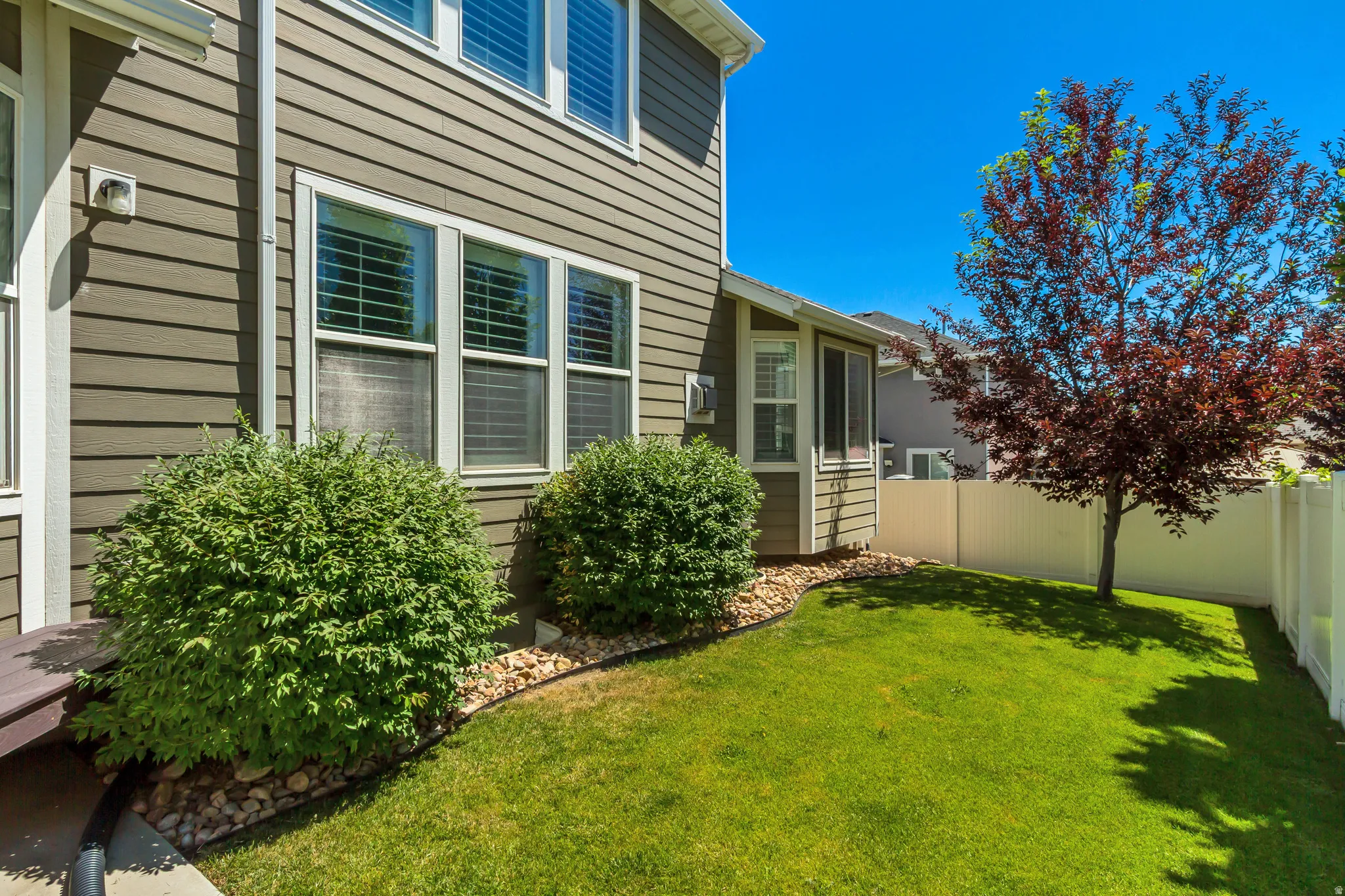 Manicured lawn area with a privacy fence and established landscaping
