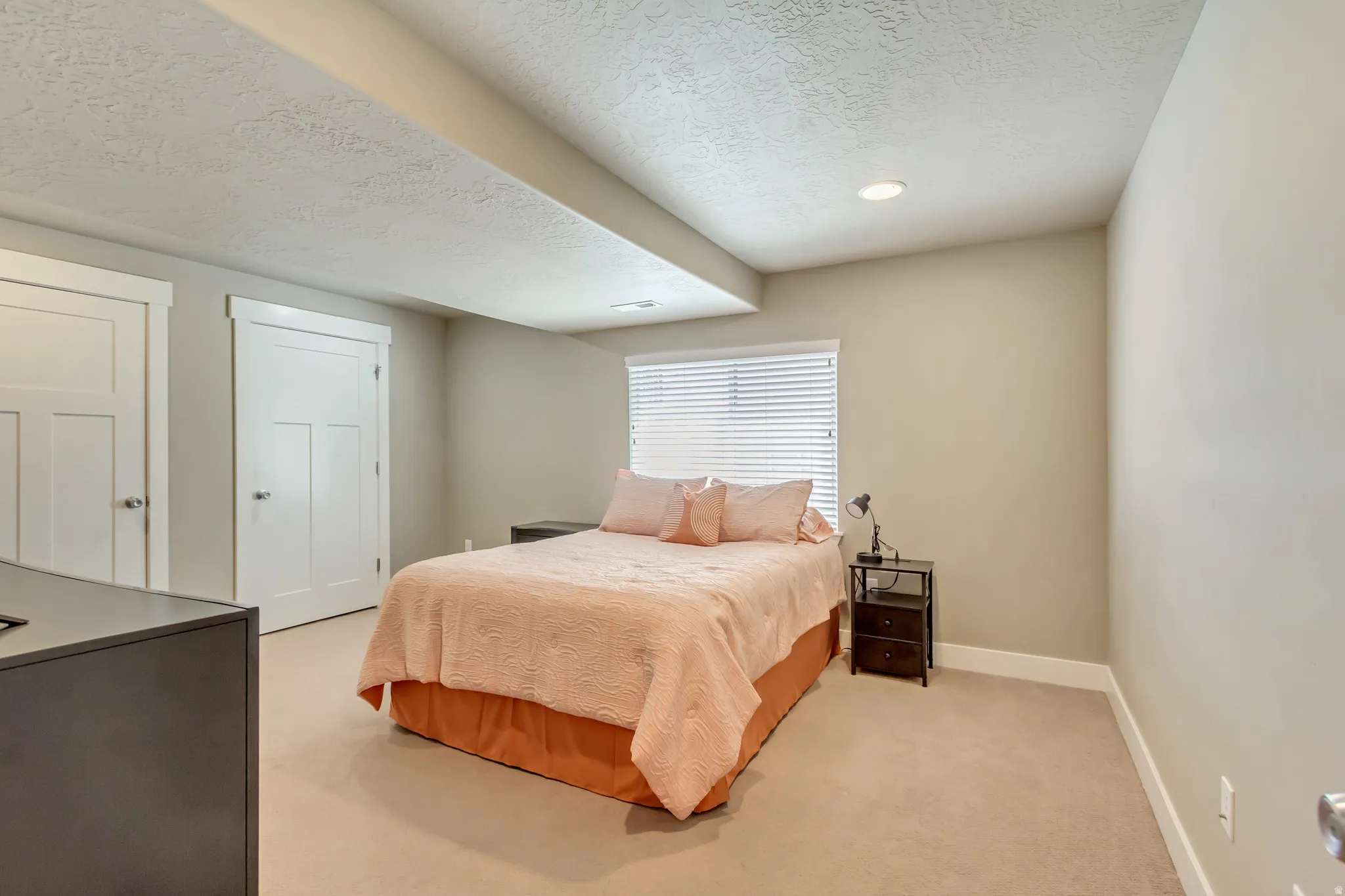 Carpeted room featuring recessed lighting and a window with horizontal blinds
