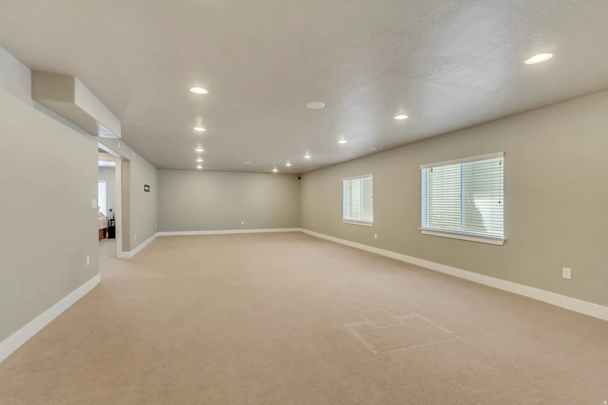 Expansive room with neutral carpeting and light gray wall tones