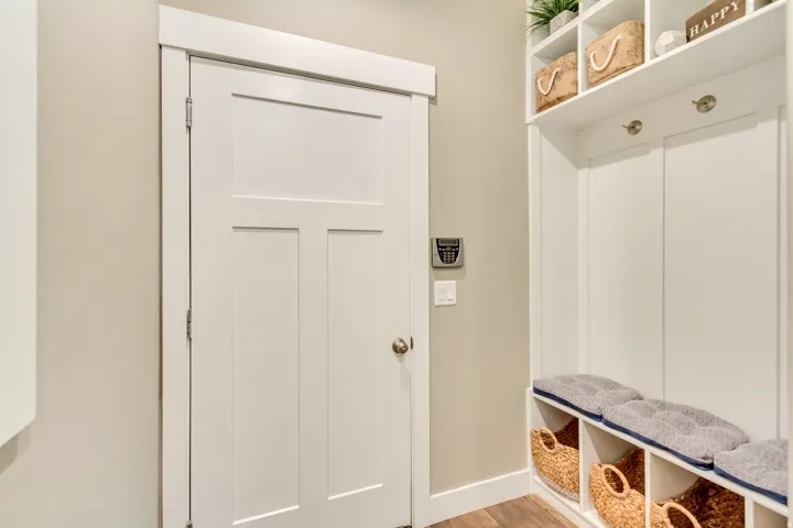 Built-in storage bench featuring cubbies, upper shelving, and coat hooks