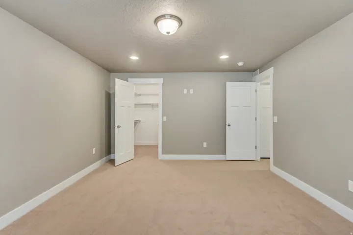 Carpeted room featuring neutral wall paint, white trim, and white interior doors