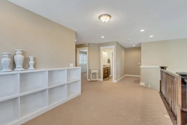 Expansive carpeted landing with built-in white shelving