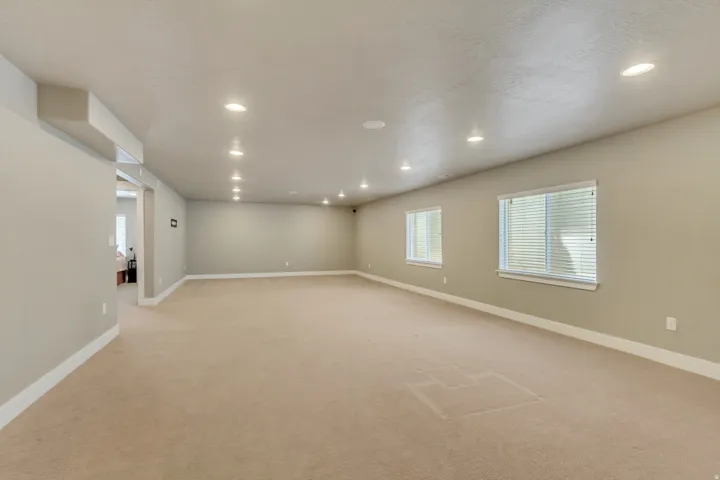 Expansive room with neutral carpeting and light gray wall tones
