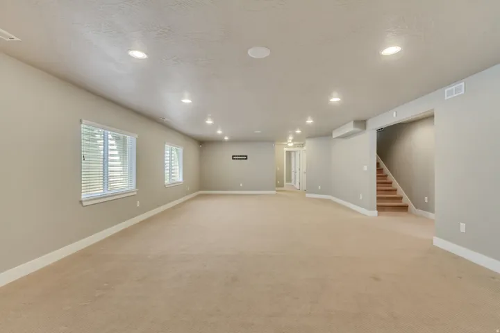 Spacious room featuring neutral paint, recessed lighting, and beige carpeting