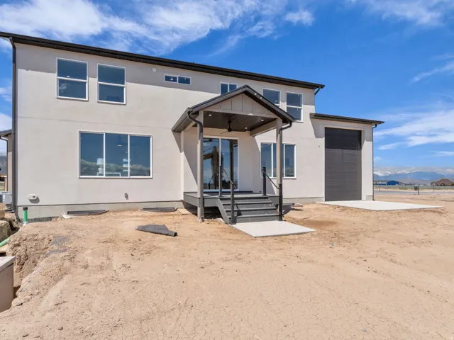 Contemporary stucco exterior with a covered porch featuring black railings and steps