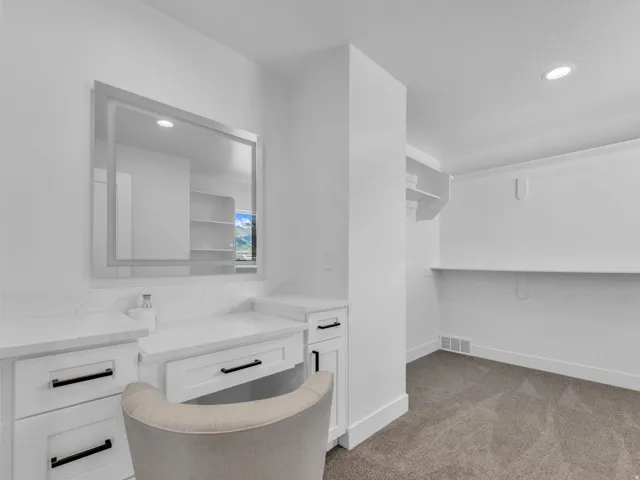 White vanity with stone countertops and black hardware