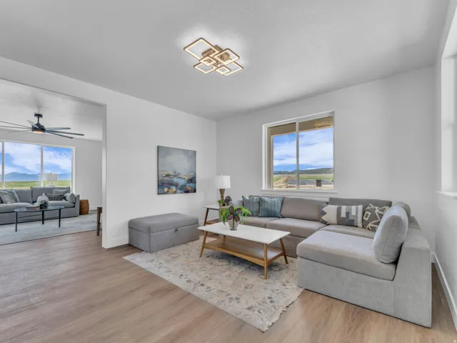 Open-concept living space featuring wood-finish flooring, recessed lighting, and large windows