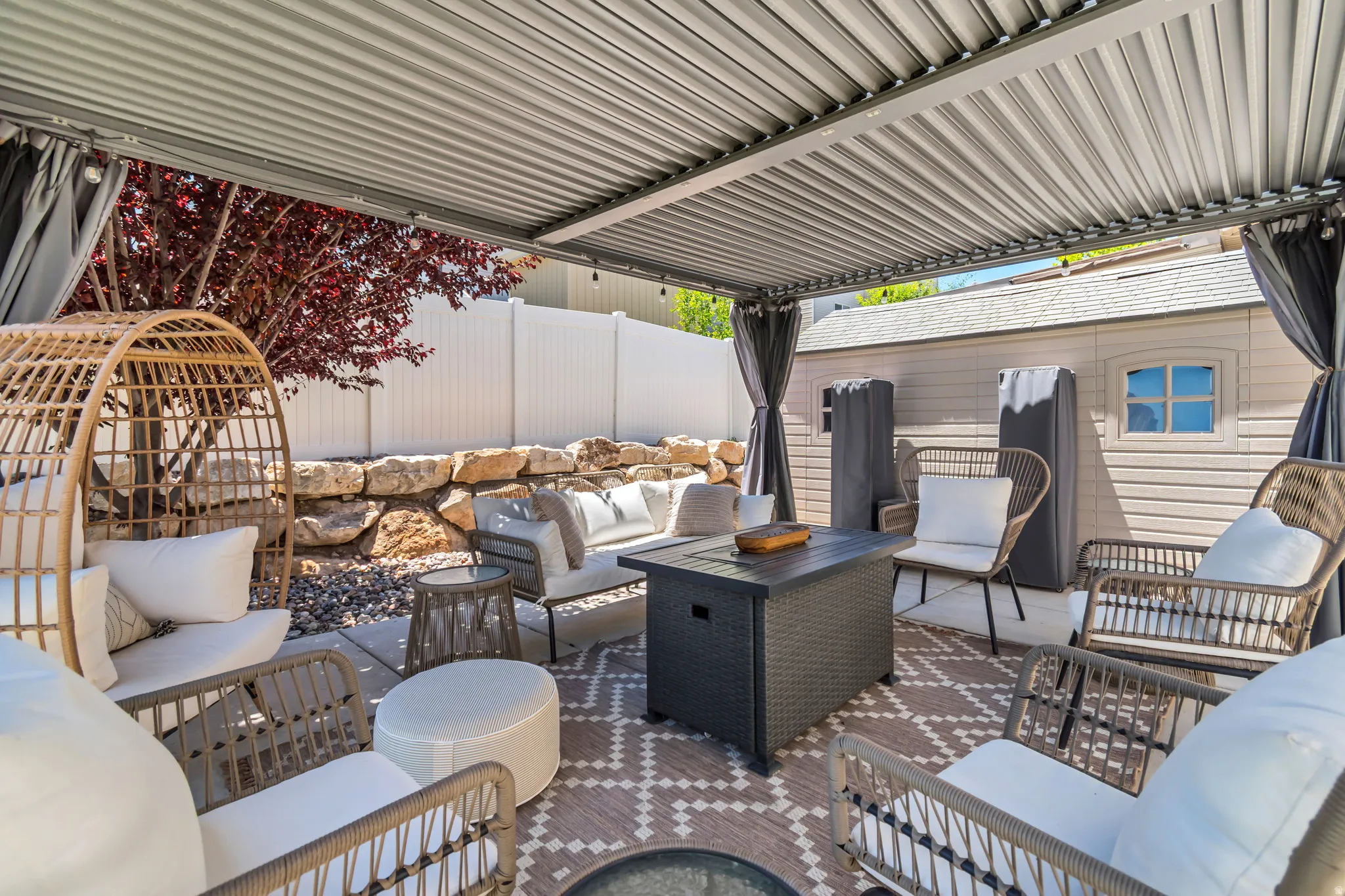 Covered patio featuring a corrugated metal roof and privacy curtains