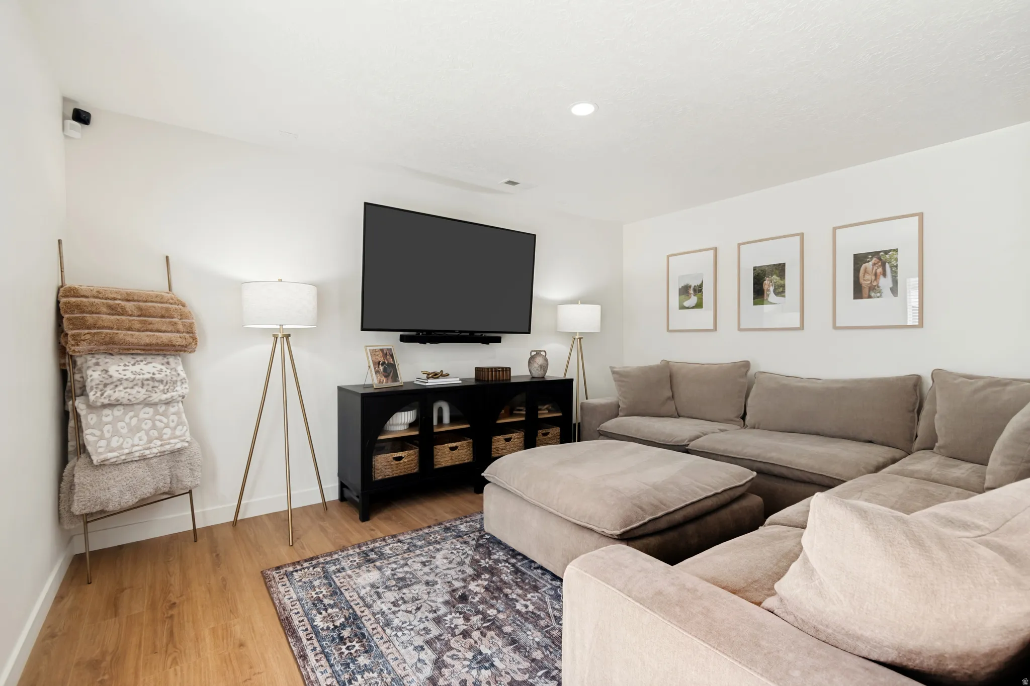 Open concept living space featuring wood-finish flooring, recessed lighting, and a modern media console