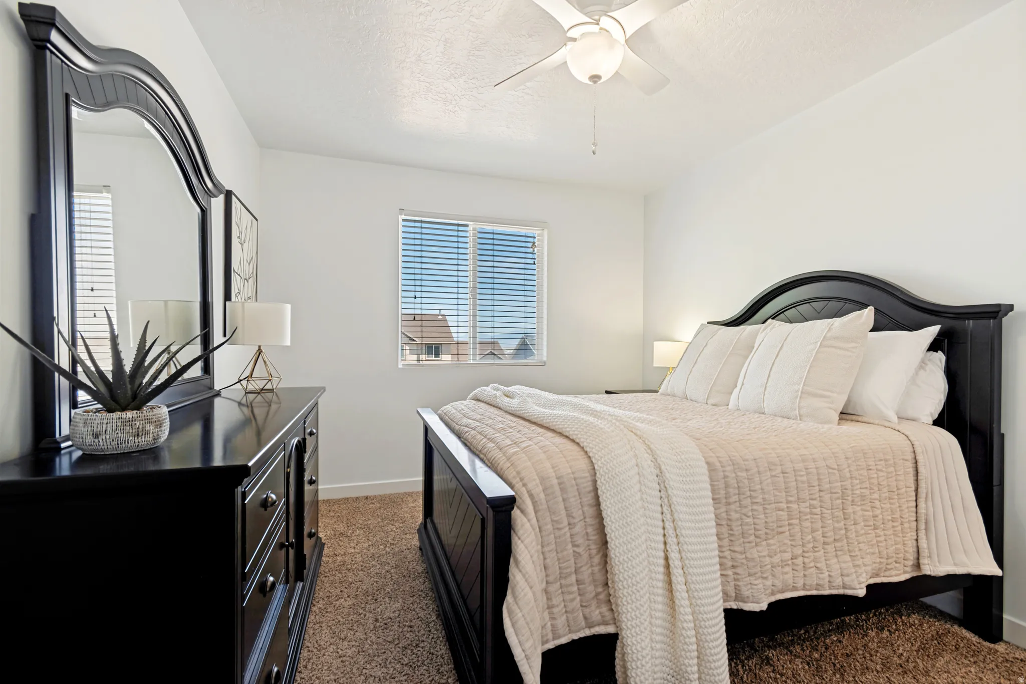 Carpeted bedroom with a window featuring horizontal blinds