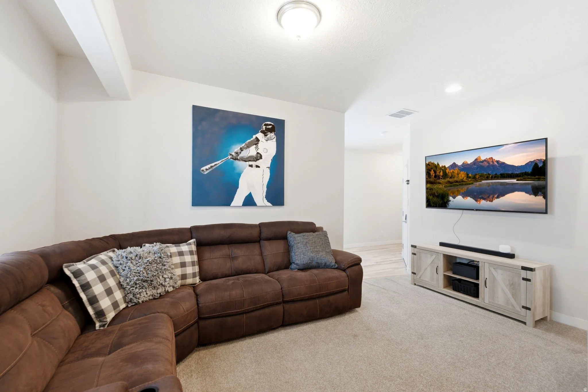 Carpeted living area featuring a recessed light, ceiling light fixture, and a wall-mounted entertainment center with open shelving and barn-door style cabinets