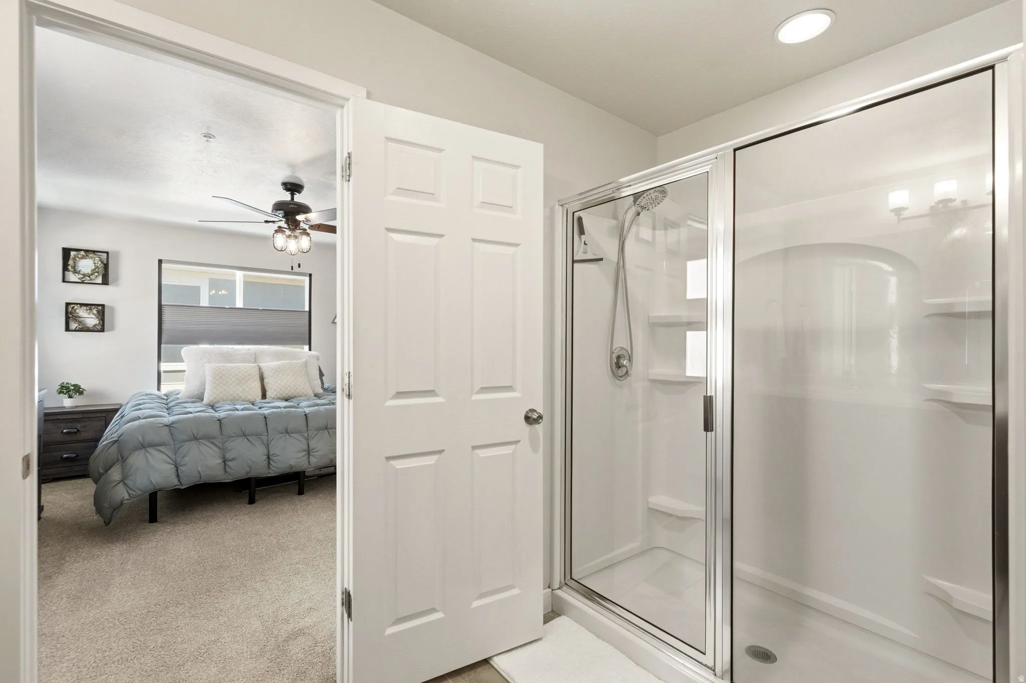 Walk-in shower with clear glass enclosure and built-in shelving