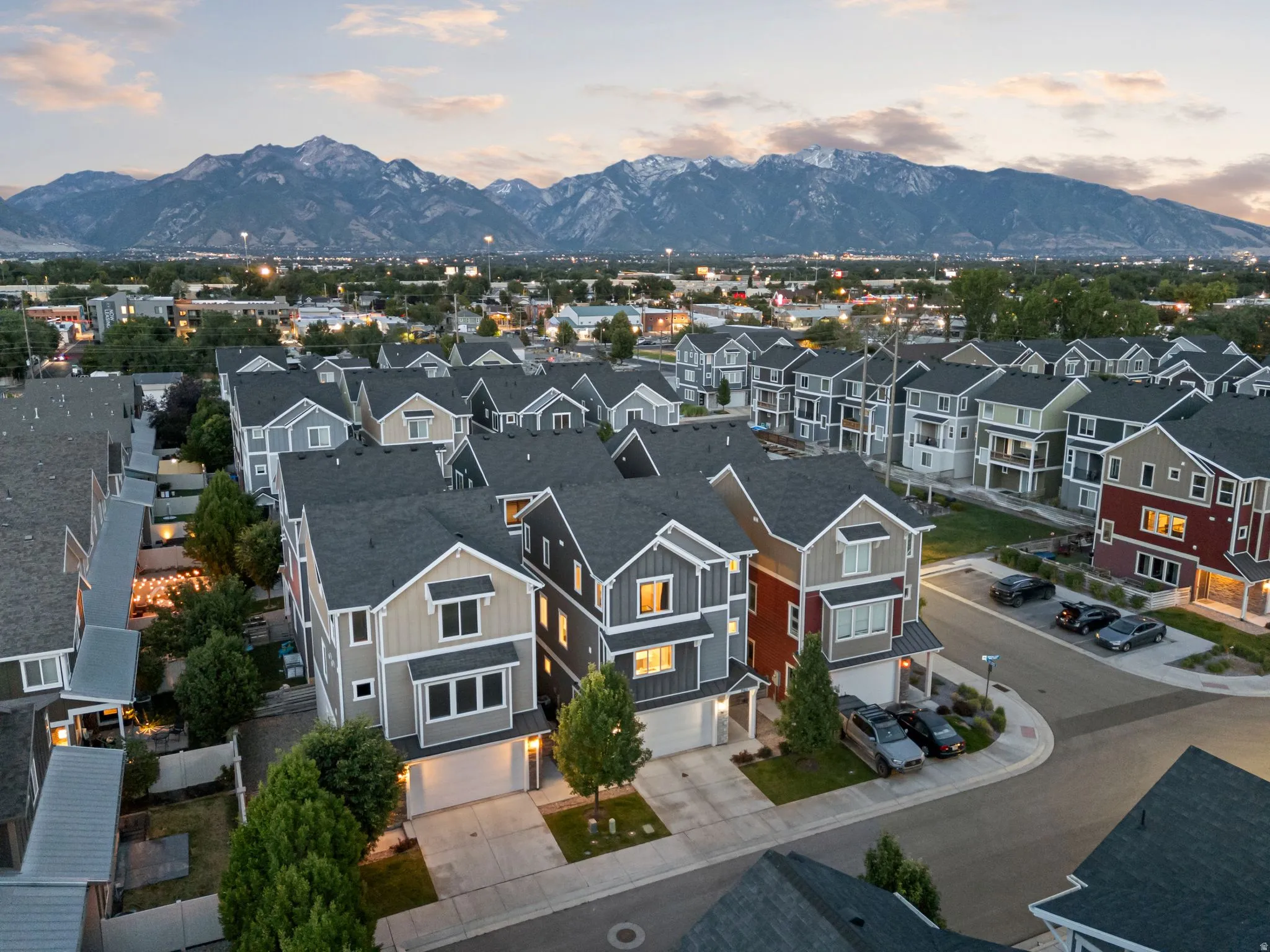 Aerial perspective showcasing a community of multi-story residences with varied exterior finishes and dark-pitched roofs