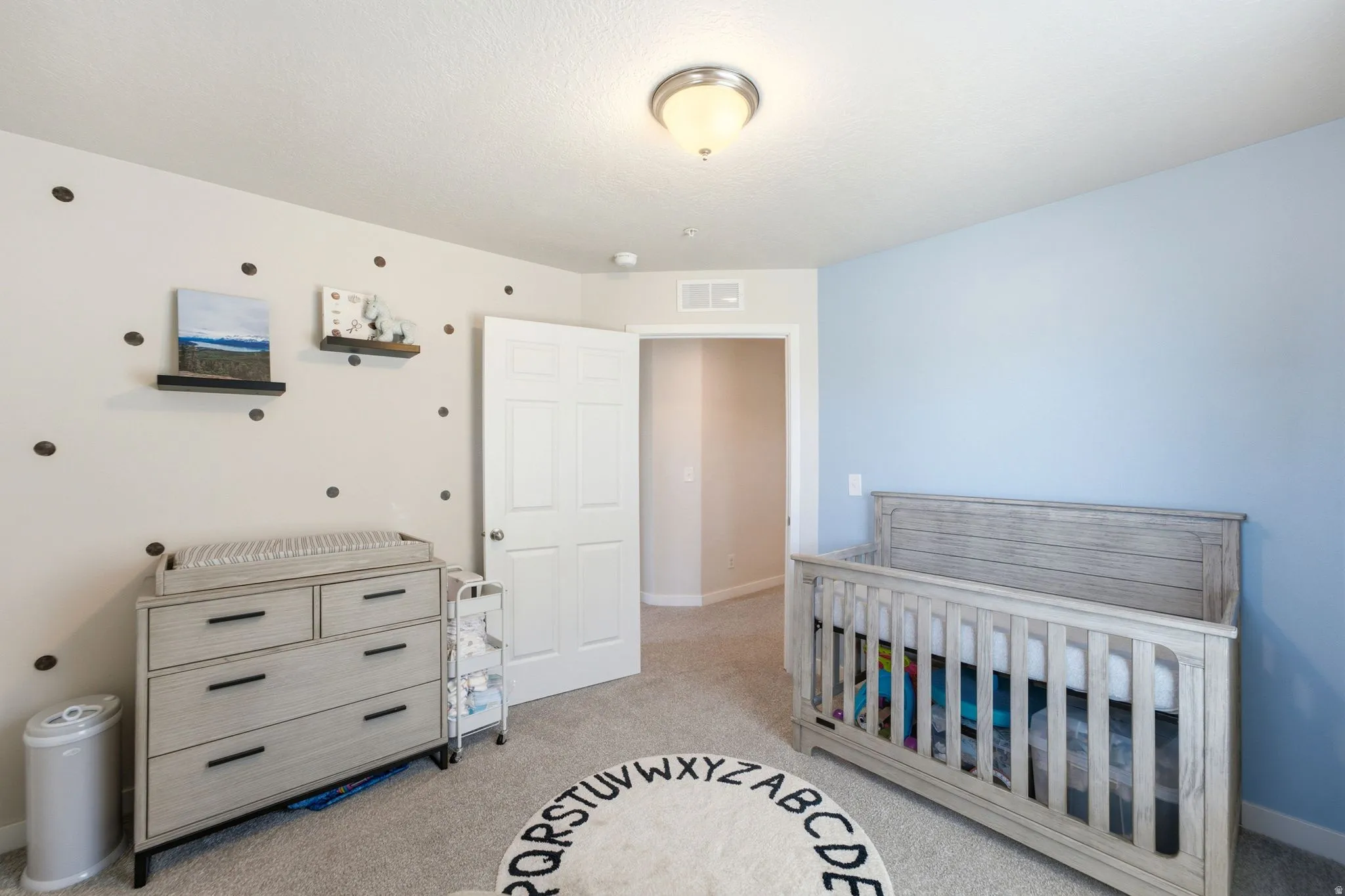 Room featuring light blue and white walls, gray carpet flooring, and a white interior door