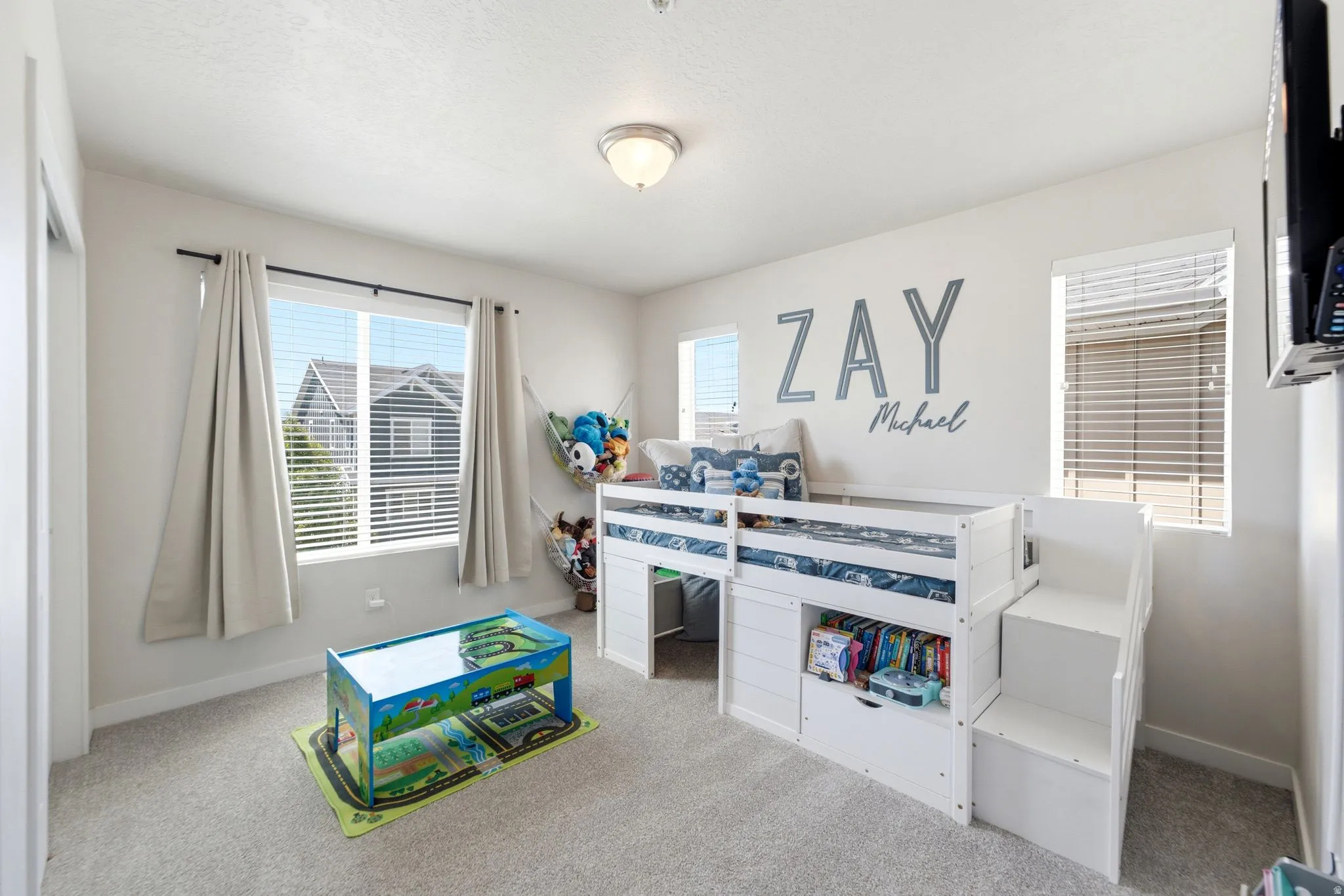 Light-filled room featuring plush gray carpeting, white walls, and multiple windows with blinds