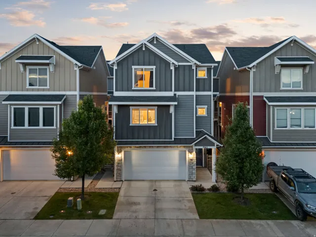 Multi-story townhome featuring a mixed-material facade with vertical and horizontal siding