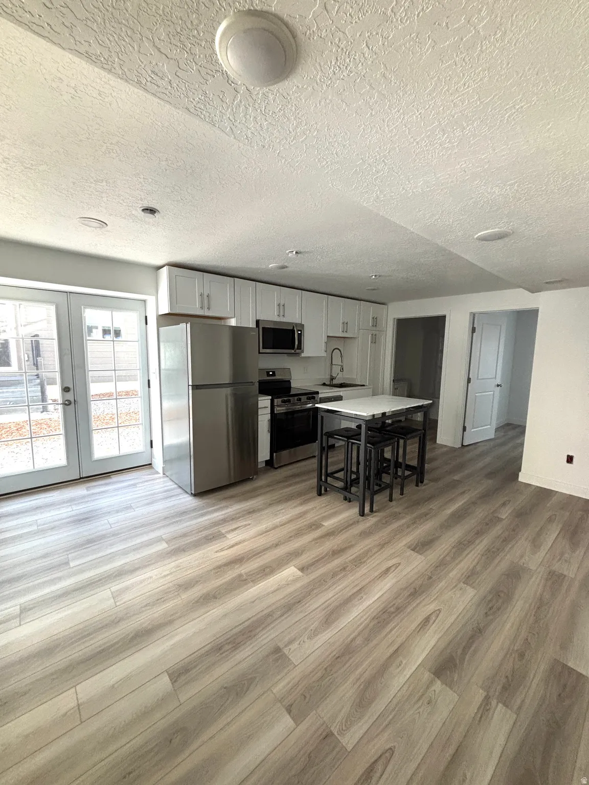 Open-concept living space featuring wood-finish flooring and white walls
