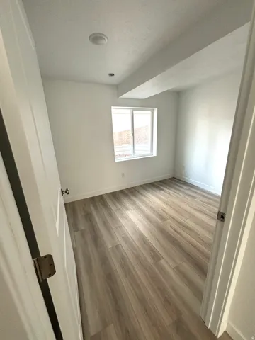 Room featuring light wood-finish flooring, white baseboards, a double-pane window, and recessed ceiling lighting