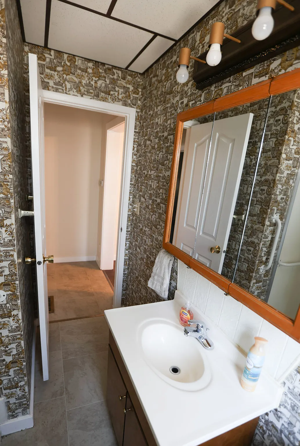 Bathroom vanity featuring a white oval sink, chrome faucet, and wood-finish cabinetry
