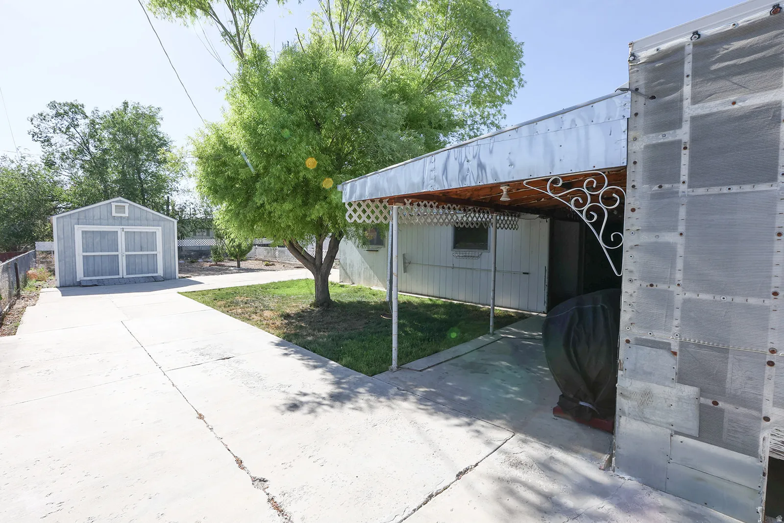 Concrete driveway leading to a detached shed