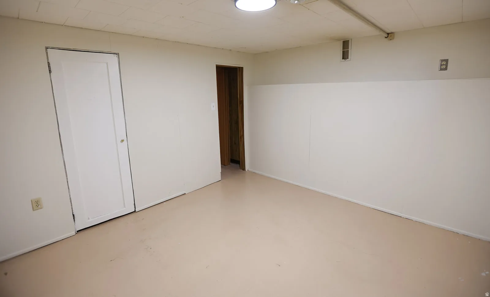 Finished room featuring light-colored flooring, white walls with an accent stripe, and a white ceiling with recessed lighting