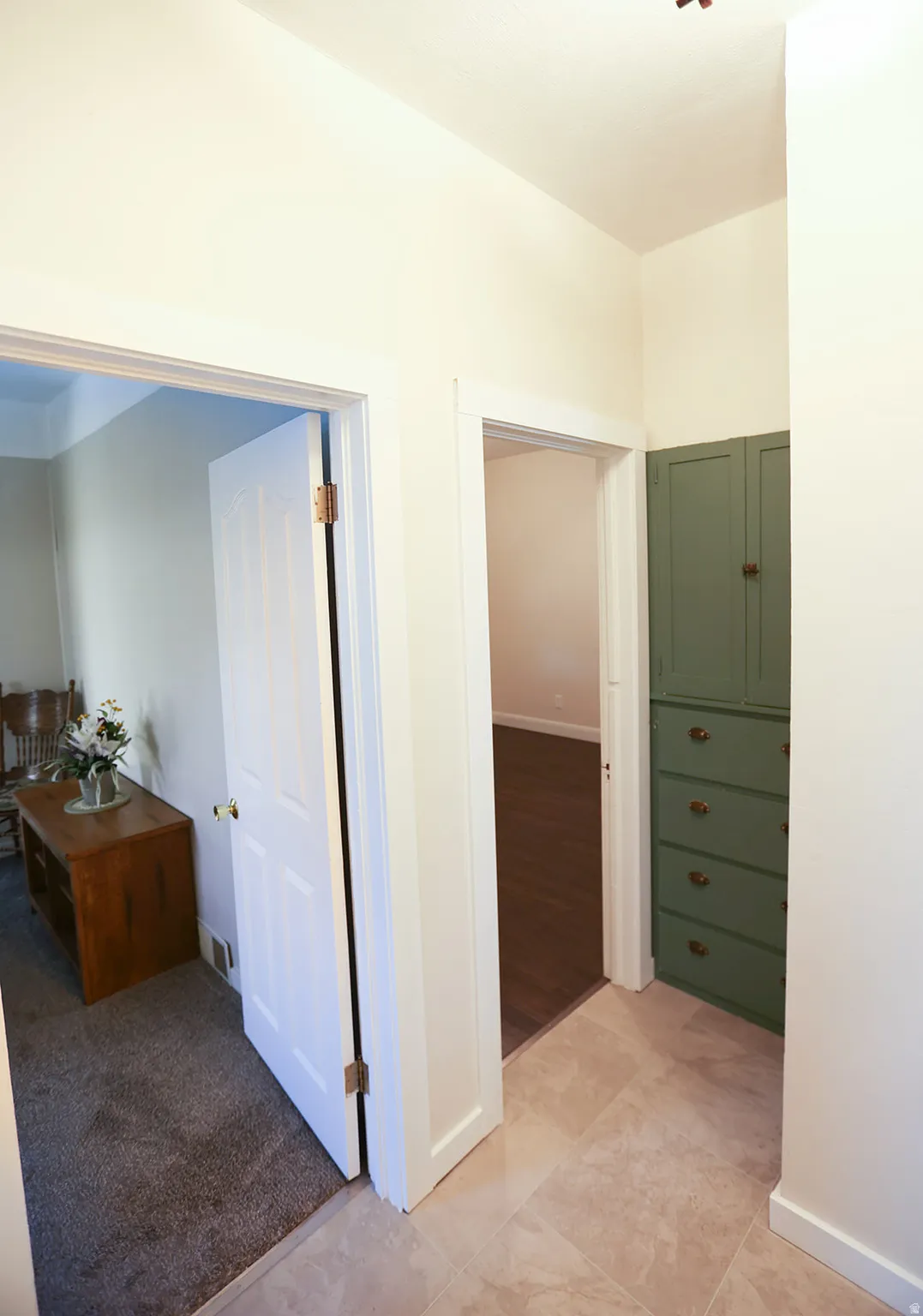 Hallway with doorways leading to bedrooms and a built-in green built-in